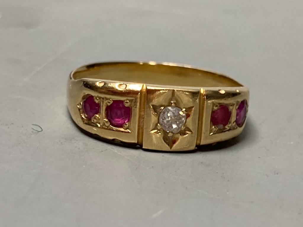 An early 20th century yellow metal, four stone ruby and single stone diamond set half hoop ring